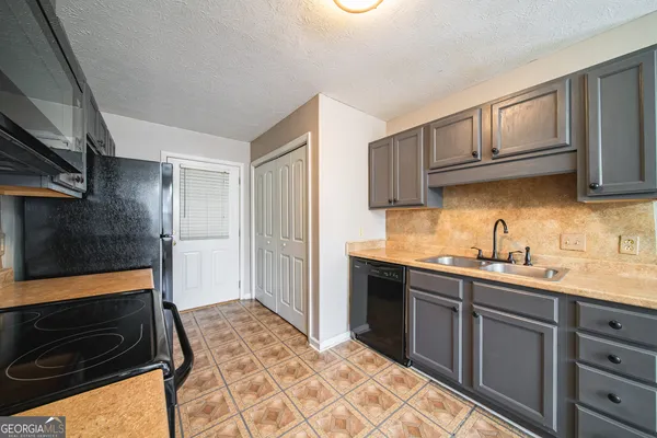 a kitchen with a sink stove and cabinets