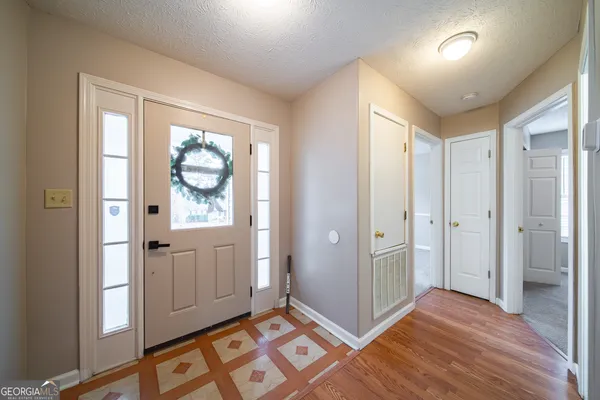 a view of an empty room with window and wooden floor