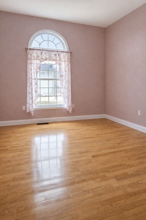 9 Arbor Road, Unit 9 Dracut, MA 01826 - Photo 7 of 27 an empty room with wooden floor and windows