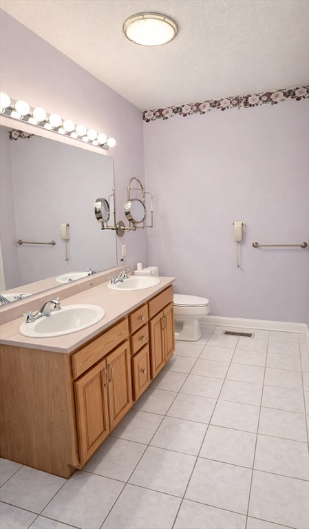 9 Arbor Road, Unit 9 Dracut, MA 01826 - Photo 10 of 27 a bathroom with a double vanity sink mirror and toilet