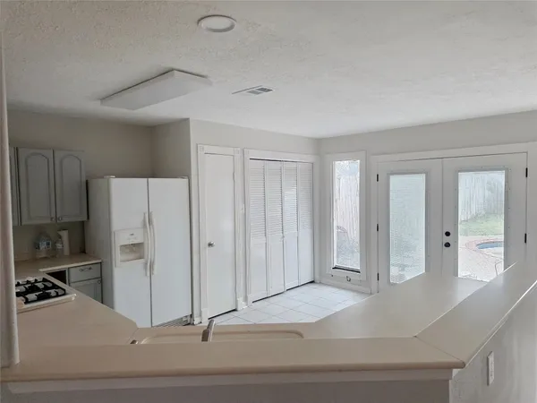 a view of a kitchen with a sink and refrigerator