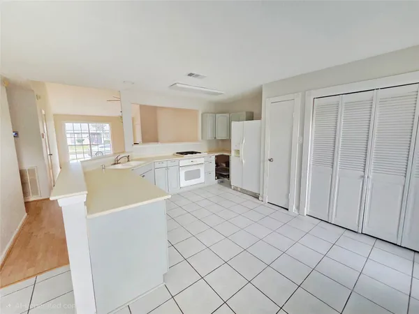 a large white kitchen with cabinets and stainless steel appliances