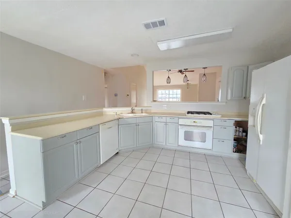 a kitchen with white cabinets a sink and white appliances
