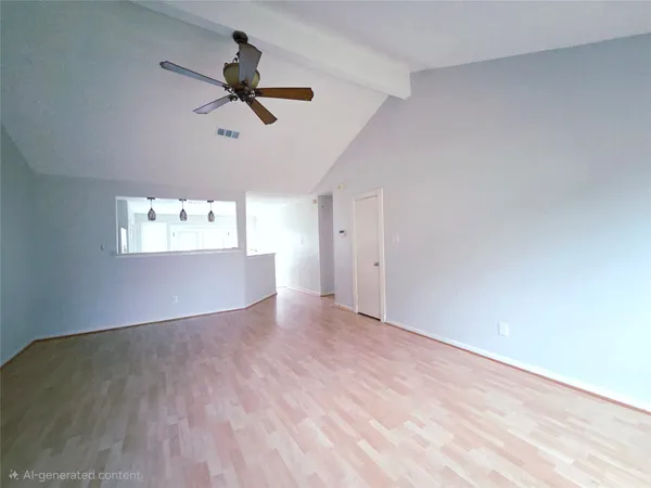 a view of empty room with wooden floor and ceiling fan