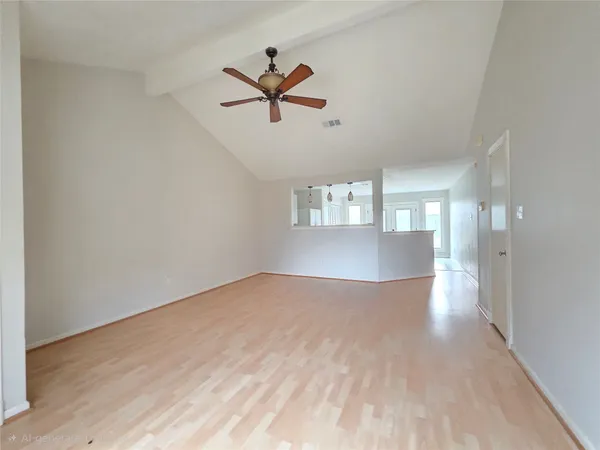 a view of empty room with wooden floor and ceiling fan