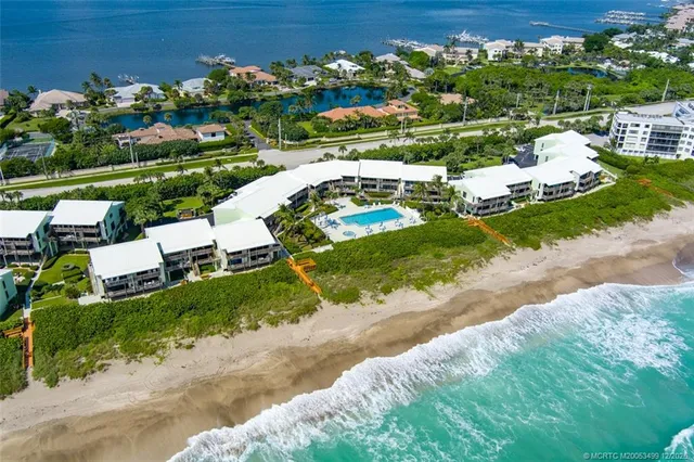 front view of a house with a yard and lake view