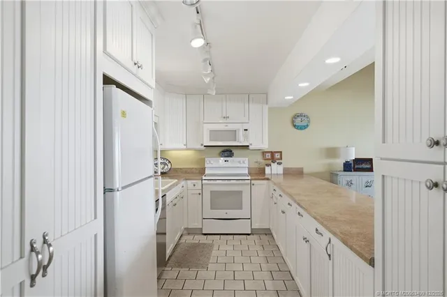 a large kitchen with kitchen island a sink stainless steel appliances and cabinets