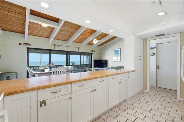 a living room with furniture a flat screen tv and a floor to ceiling window