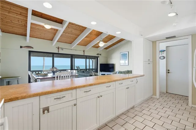 a living room with furniture a flat screen tv and a floor to ceiling window
