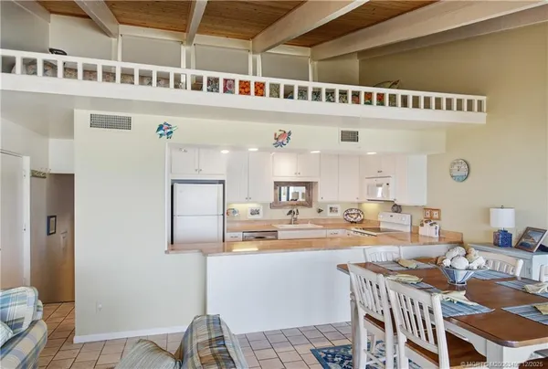 a kitchen with a sink white cabinets and white appliances
