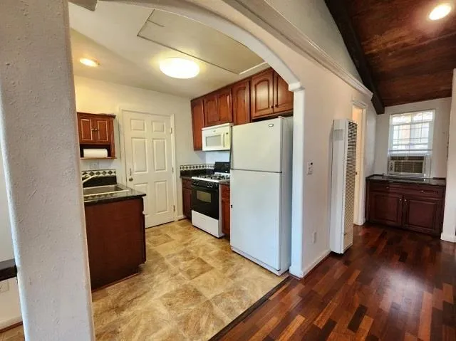 a kitchen with granite countertop a refrigerator and a stove top oven