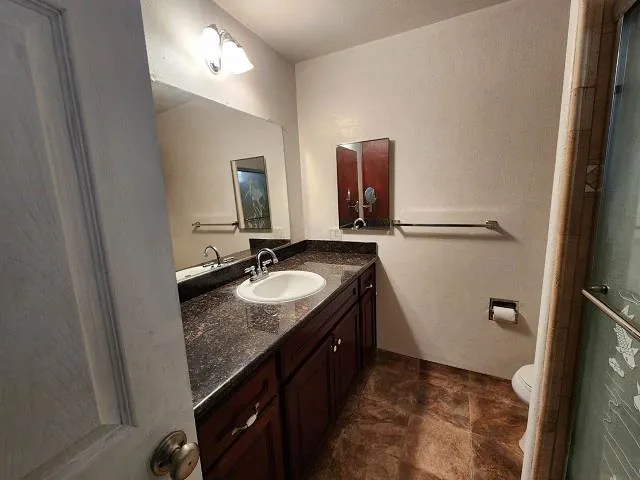 a bathroom with a granite countertop sink and a mirror