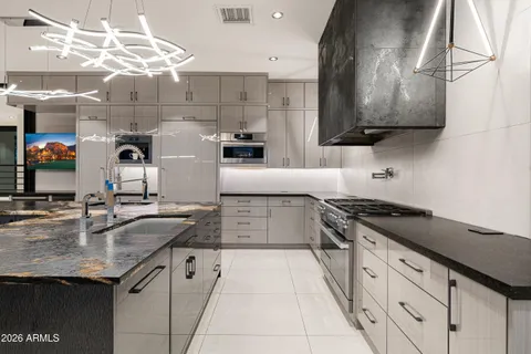a kitchen with granite countertop a sink and a stove top oven