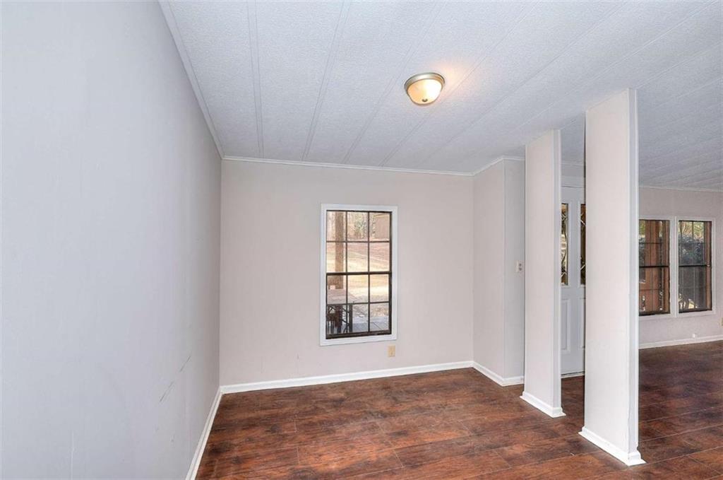1210 Lee Peters Road Loganville, GA 30052 - Photo 20 of 32 a view of an empty room with wooden floor and a window