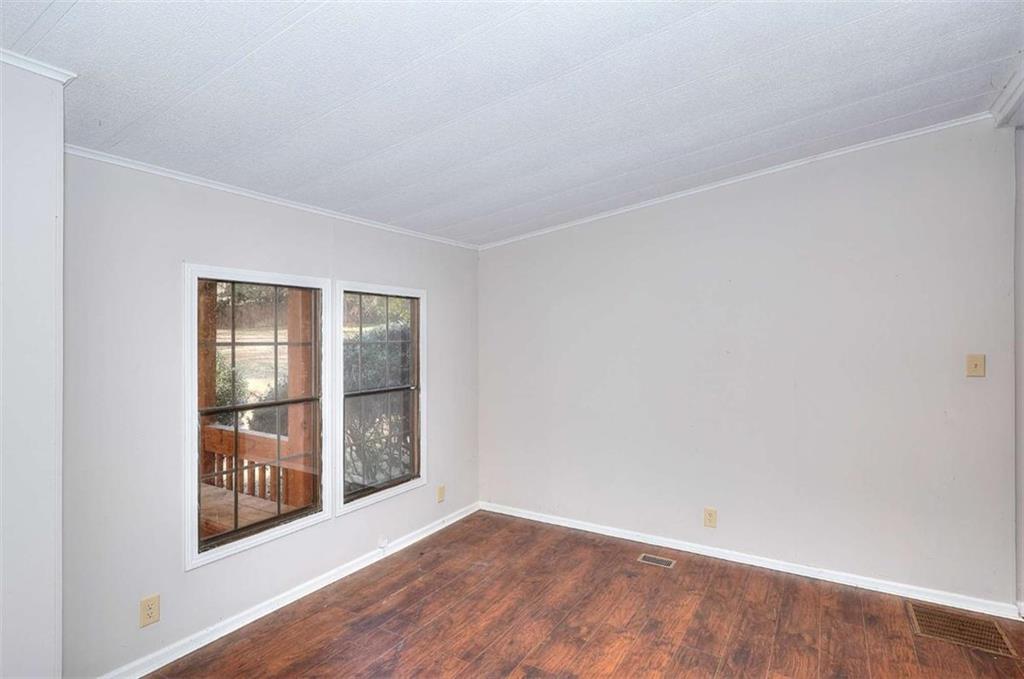 1210 Lee Peters Road Loganville, GA 30052 - Photo 21 of 32 an empty room with wooden floor and windows