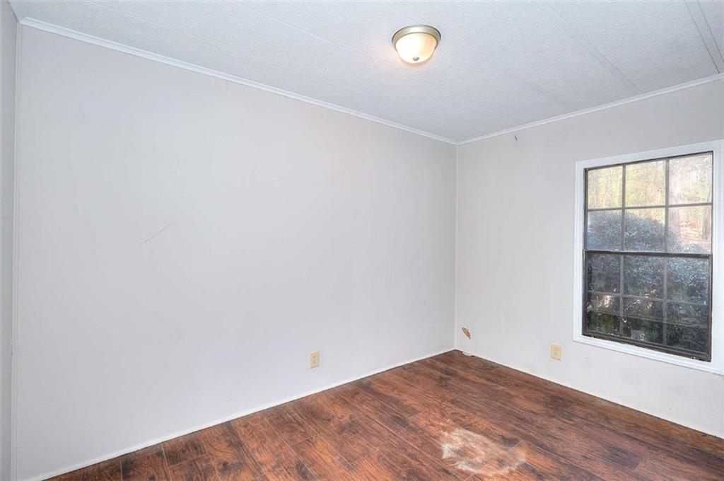 1210 Lee Peters Road Loganville, GA 30052 - Photo 26 of 32 a view of an empty room with wooden floor and a window