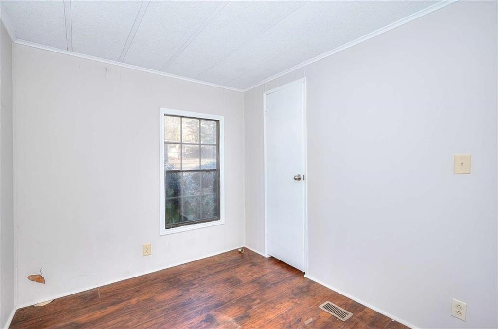 1210 Lee Peters Road Loganville, GA 30052 - Photo 27 of 32 a view of an empty room with wooden floor and a window