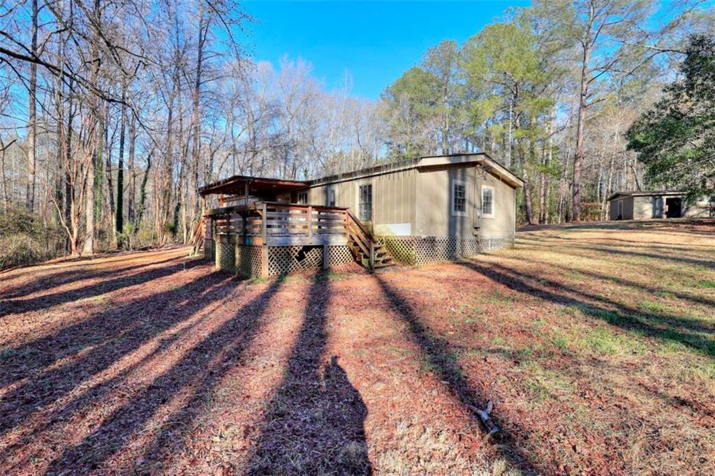 1210 Lee Peters Road Loganville, GA 30052 - Photo 5 of 32 a view of a house with backyard and trees