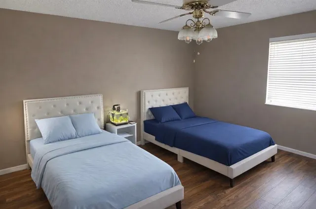 a bedroom with a bed lamp and a chandelier