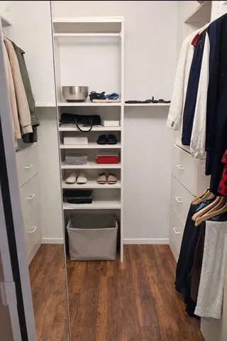 a view of walk in closet with clothes and shoes