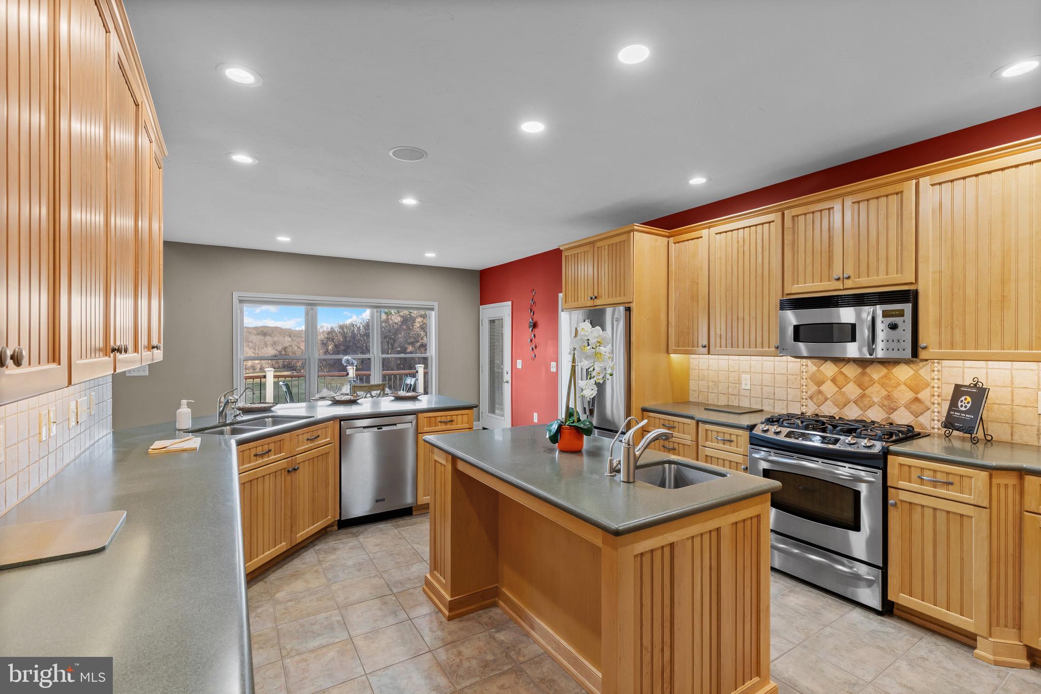 3239 Dry Branch Road White Hall, MD 21161 - Photo 21 of 56 a kitchen with stainless steel appliances granite countertop a stove top oven a sink dishwasher a refrigerator and cabinets with wooden floor
