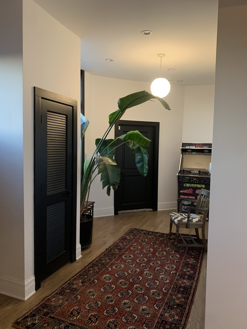 5259 West Roscoe Street, Unit 1F Chicago, IL 60641 - Photo 16 of 53 a view of a hallway with wooden floor and a carpet