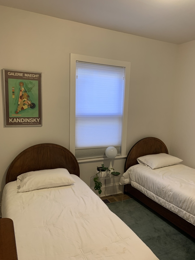 5259 West Roscoe Street, Unit 1F Chicago, IL 60641 - Photo 29 of 53 a bedroom with a bed and a painting on the wall