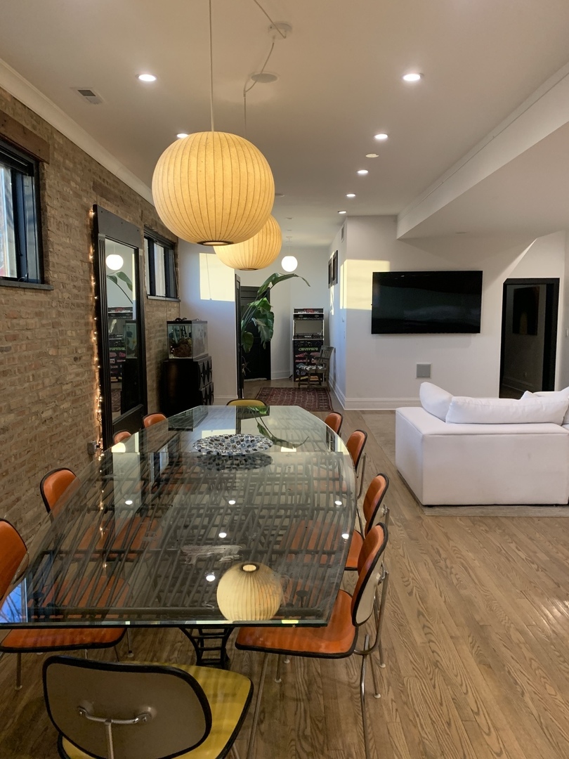 5259 West Roscoe Street, Unit 1F Chicago, IL 60641 - Photo 3 of 53 a living room with furniture a flat screen tv and kitchen view