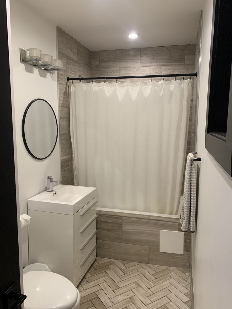 5259 West Roscoe Street, Unit 1F Chicago, IL 60641 - Photo 33 of 53 a bathroom with a sink toilet and a mirror