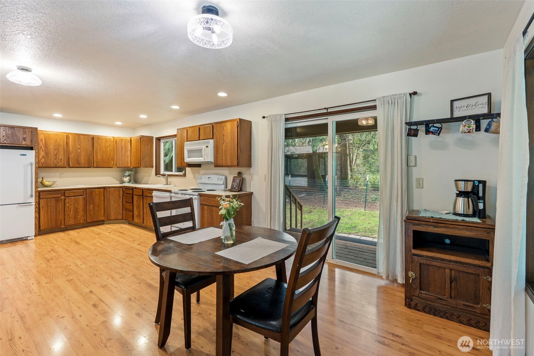 209 Alpha Way Onalaska, WA 98570 - Photo 12 of 40 a kitchen with a table chairs refrigerator and cabinets