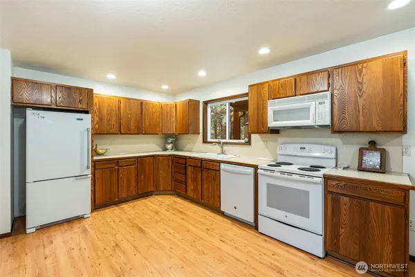 a kitchen with a refrigerator a stove top oven a sink and cabinets