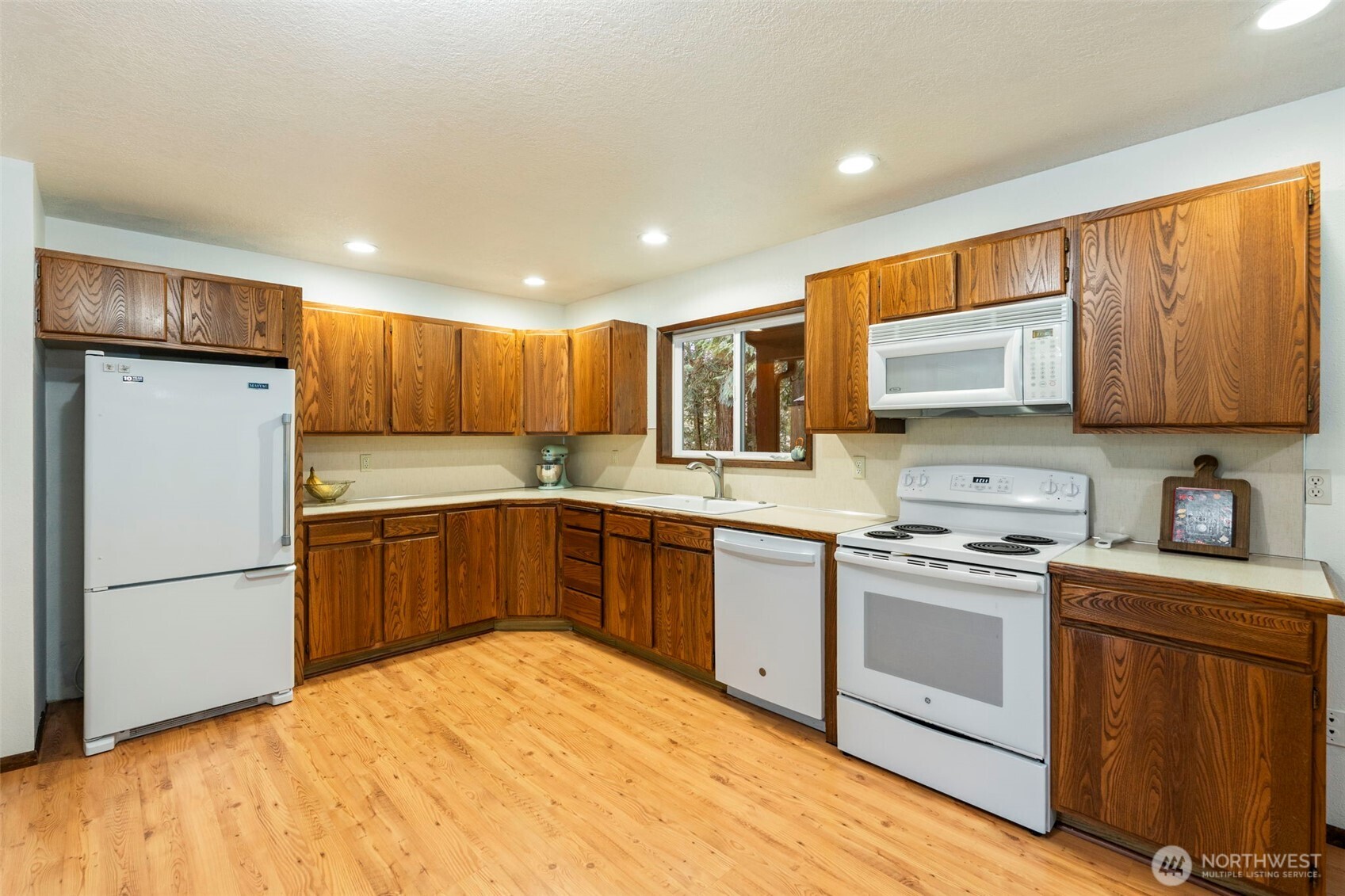 209 Alpha Way Onalaska, WA 98570 - Photo 10 of 40 a kitchen with a refrigerator a stove top oven a sink and cabinets