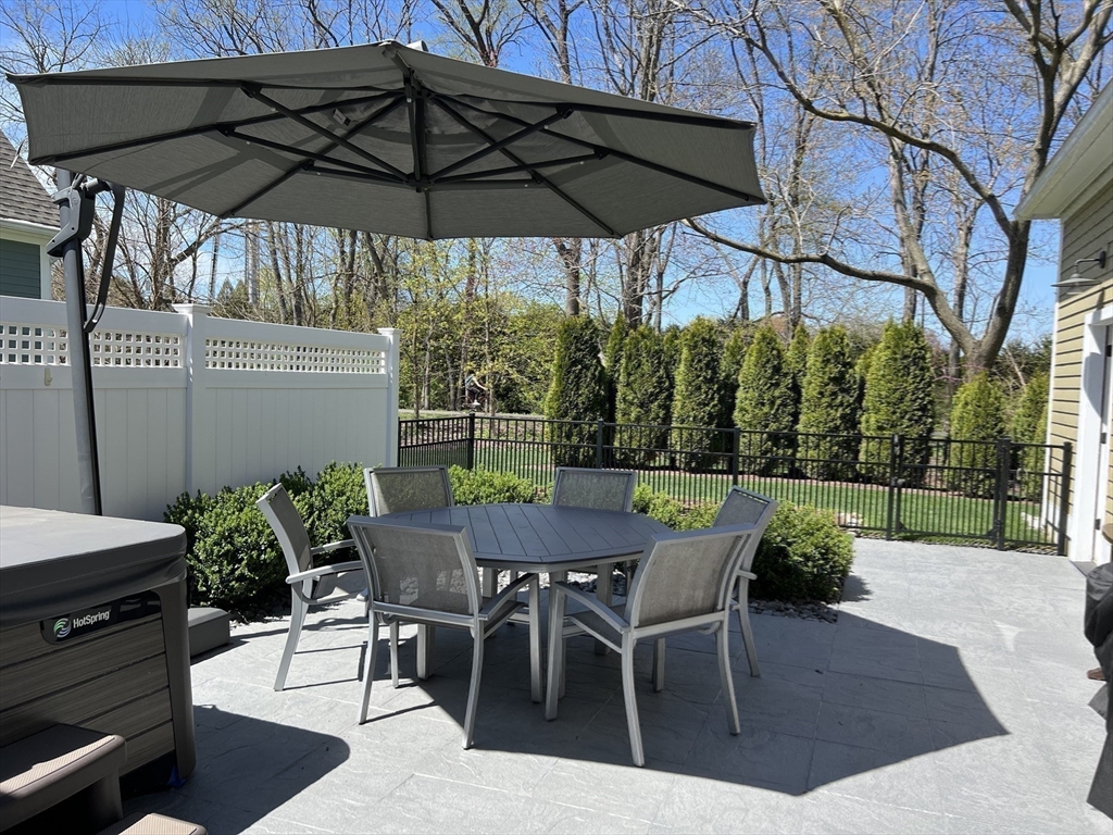 6 East Commons Drive, Unit 6 Hadley, MA 01035 - Photo 18 of 27 a view of a patio with table and chairs under an umbrella