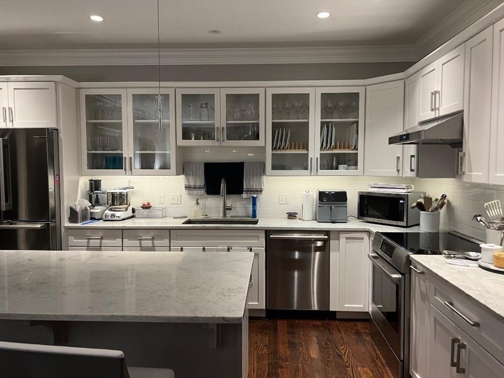 6 East Commons Drive, Unit 6 Hadley, MA 01035 - Photo 3 of 27 a kitchen with stainless steel appliances granite countertop a stove a sink dishwasher a microwave oven and a refrigerator with wooden floor