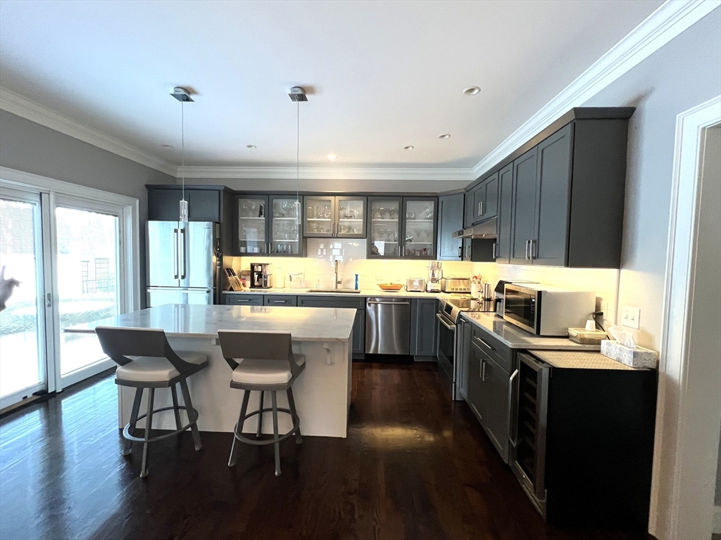 6 East Commons Drive, Unit 6 Hadley, MA 01035 - Photo 5 of 27 a kitchen with stainless steel appliances granite countertop a stove top oven a sink dishwasher a dining table and chairs with wooden floor