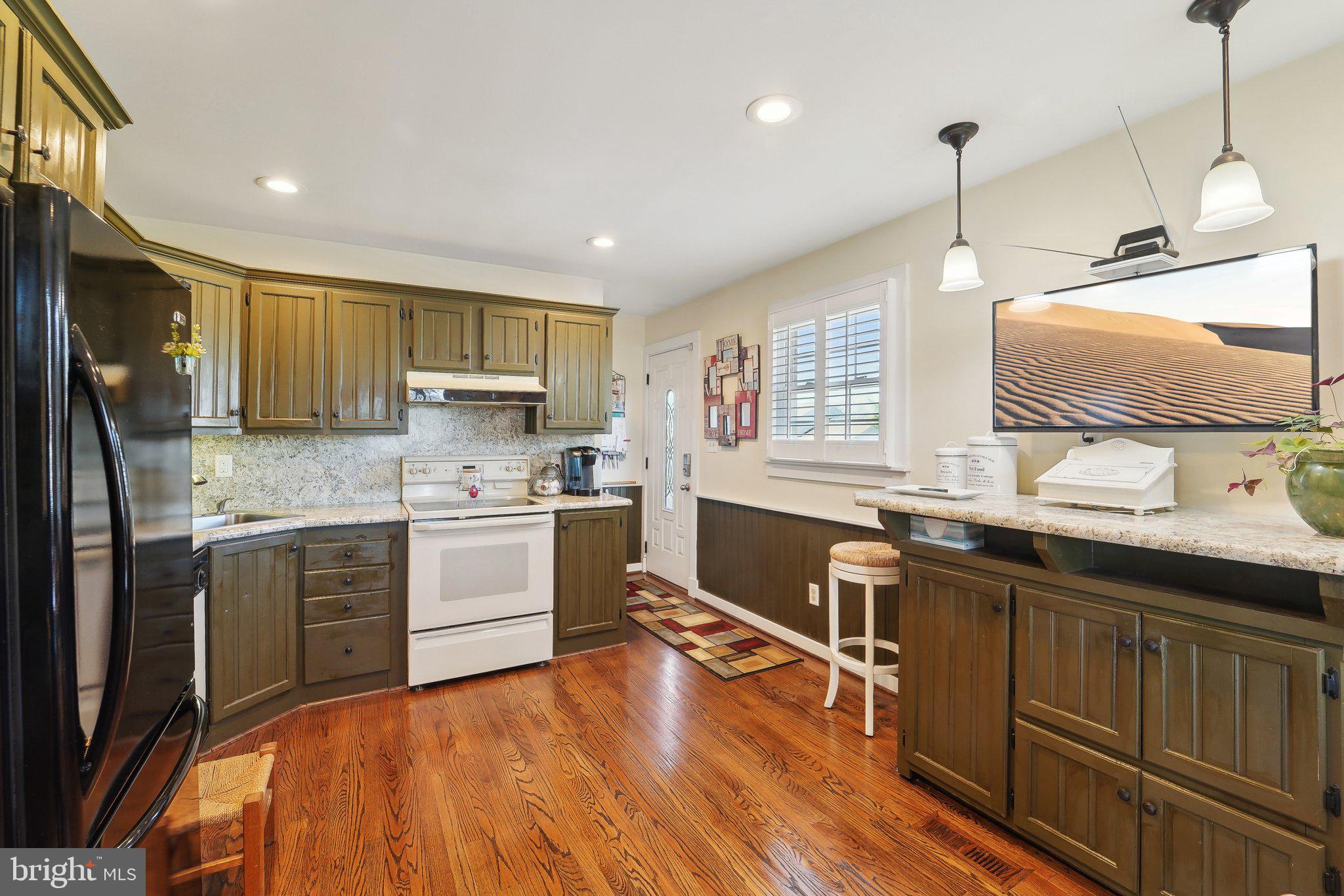 901 Mark Road Baltimore, MD 21225 - Photo 8 of 39 a kitchen with granite countertop wooden floors appliances and cabinets