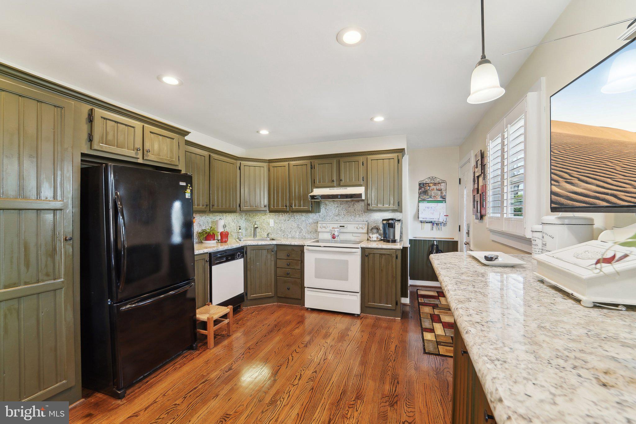 901 Mark Road Baltimore, MD 21225 - Photo 9 of 39 a kitchen with stainless steel appliances granite countertop a refrigerator a sink dishwasher a stove and white countertops with wooden floor