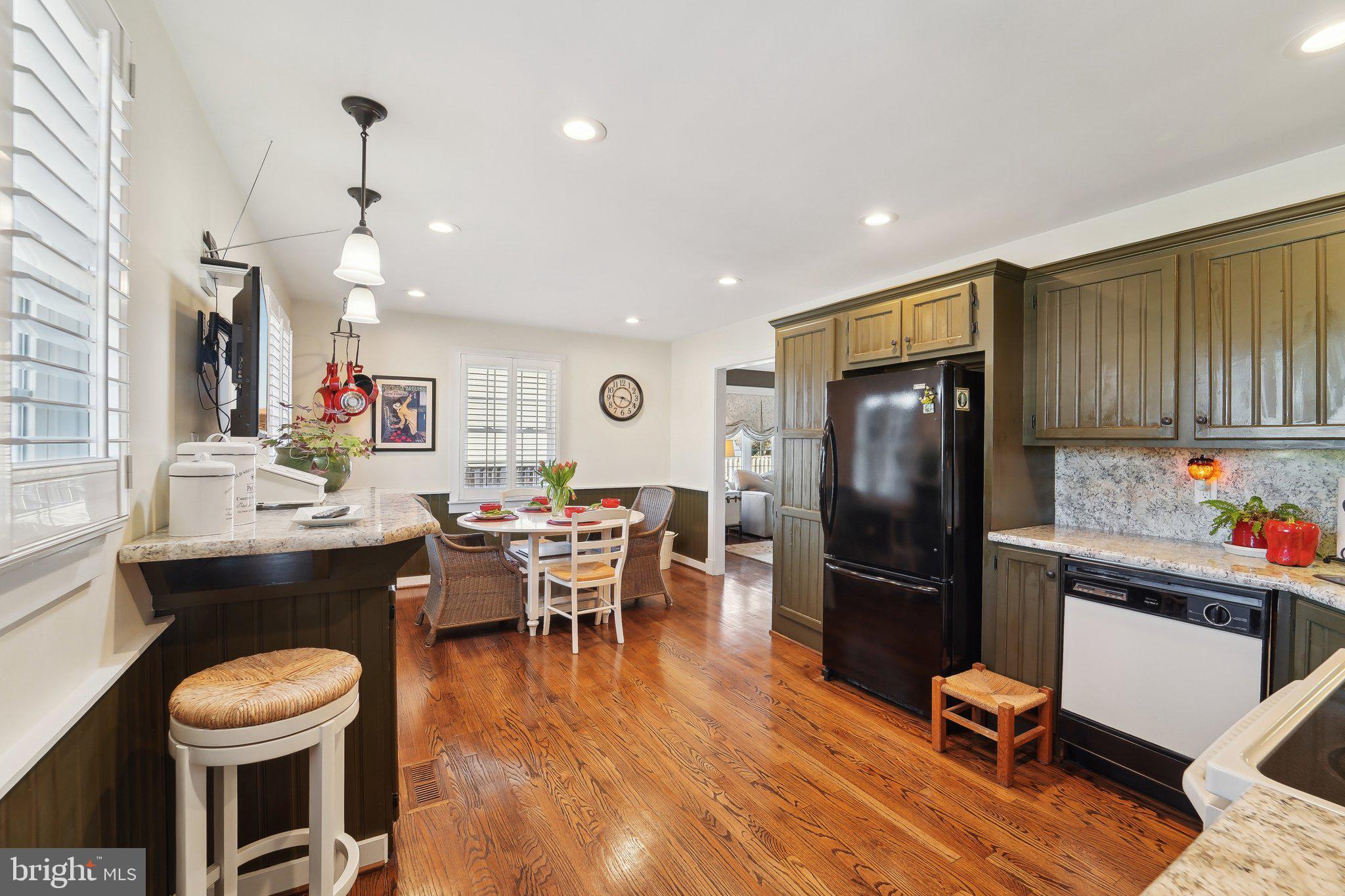 901 Mark Road Baltimore, MD 21225 - Photo 10 of 39 a kitchen with stainless steel appliances a dining table chairs stove refrigerator and cabinets