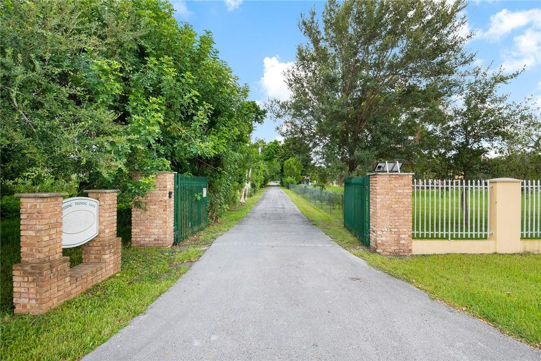 13470 Stirling Road Southwest Ranches, FL 33330 - Photo 9 of 13 a view of a house with a small yard and wooden fence