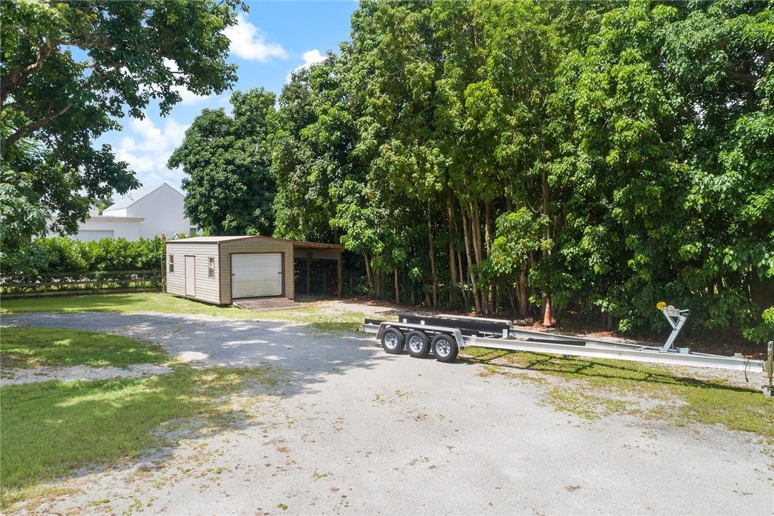 13470 Stirling Road Southwest Ranches, FL 33330 - Photo 10 of 13 a view of a swimming pool with a lounge chair and trees