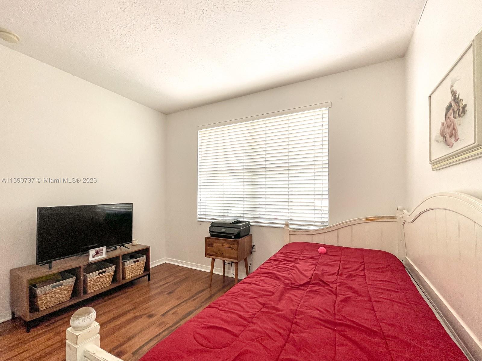 3136 Southwest 129th Way, Unit 157 Miramar, FL 33027 - Photo 16 of 23 a bedroom with a bed and a flat screen tv
