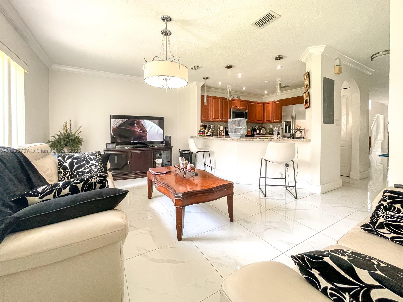 3136 Southwest 129th Way, Unit 157 Miramar, FL 33027 - Photo 7 of 23 a living room with furniture and a flat screen tv