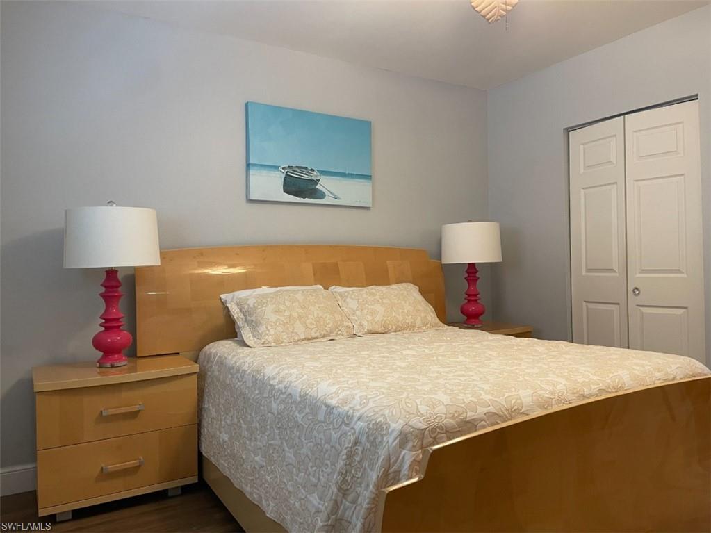 940 3rd Street South, Unit 202 Naples, FL 34102 - Photo 8 of 9 a bedroom with a bed and a lamp on dresser
