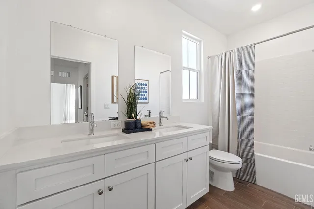 a bathroom with a granite countertop sink toilet a large mirror a bathtub and next to a window