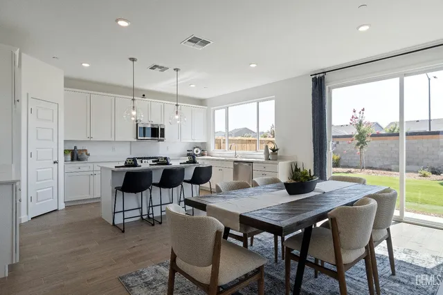 a kitchen with a dining table chairs and white appliances
