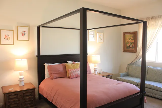 a bedroom with a bed and a lamp next to a window