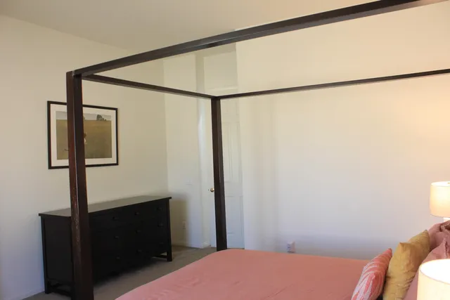 a bedroom with a bed and a mirror