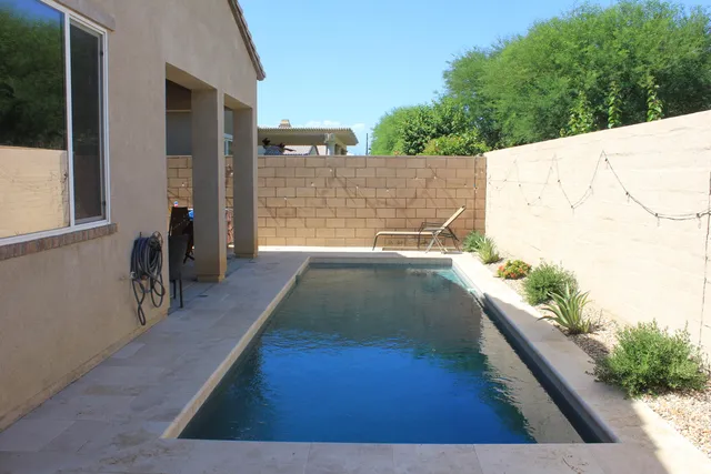 a view of swimming pool with outdoor seating and plants