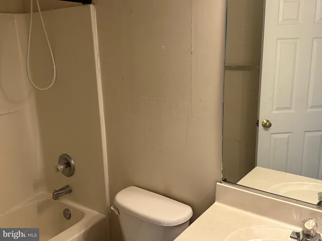 a white toilet and tub sitting next to a bathroom sink