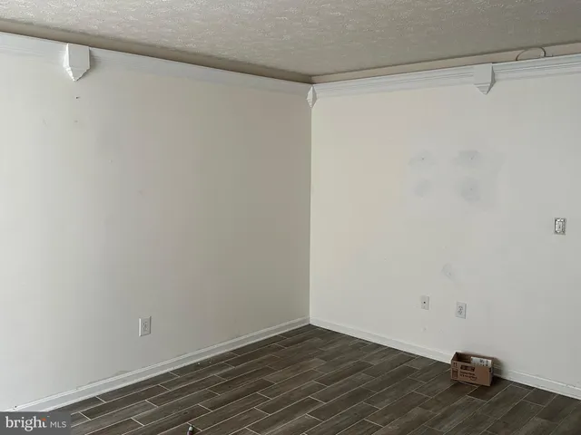 a view of a room with wooden floor and white walls